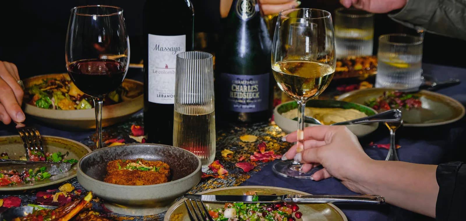 A celebration table at Royâ — shared plates, wine and champagne