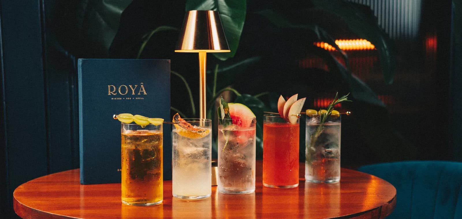 The Royâ cocktail bar — woven pendant lights, brass bar and velvet stools